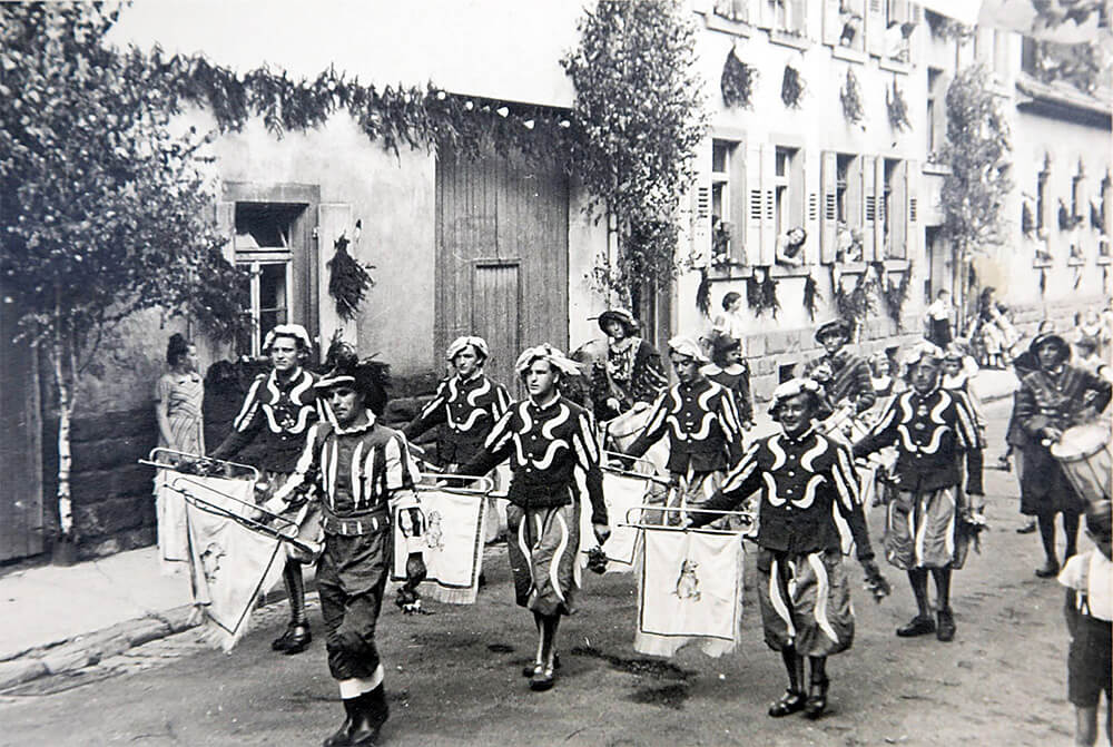 Fanfaren- und Trommlerzug, die Stadt ist 1950 mit Bäumen und Schmuck festlich herausgeputzt.